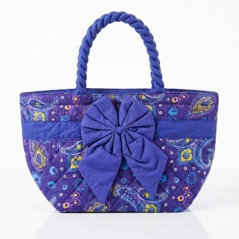 NaRaYa handbag featuring a purple paisley print, quilted fabric, and a large decorative bow on the front.