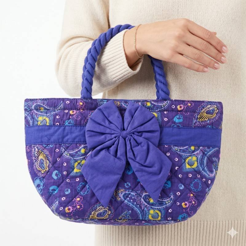 NaRaYa handbag featuring a purple paisley print, quilted fabric, and a large decorative bow on the front. - view 2